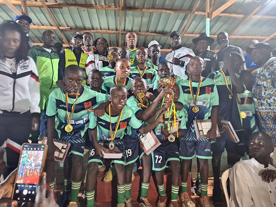 Jeunes vainqueurs d'une catégorie de minimes, médailles au cou et trophée en main, au stade d'Oyack Rail